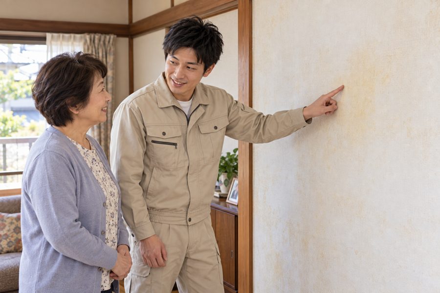 お客様と壁の状態を確認しながら打ち合わせする様子